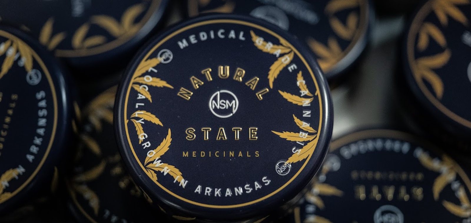 Natural State Medicinals branded tin lids, medical-grade cannabis locally grown in Arkansas